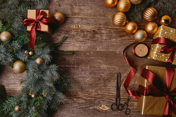 在木桌上的圣诞礼物盒, 杉木花圈, 丝带线轴和剪刀的高视图