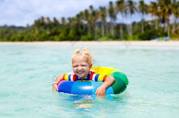 热带海滩上的孩子。海上度假与孩子.
