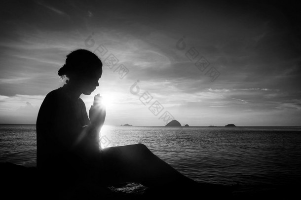 年轻女子在日落祷告