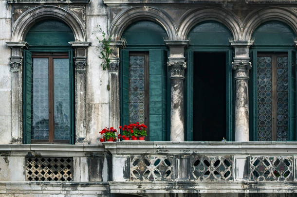 威尼斯老式阳台上的红花.