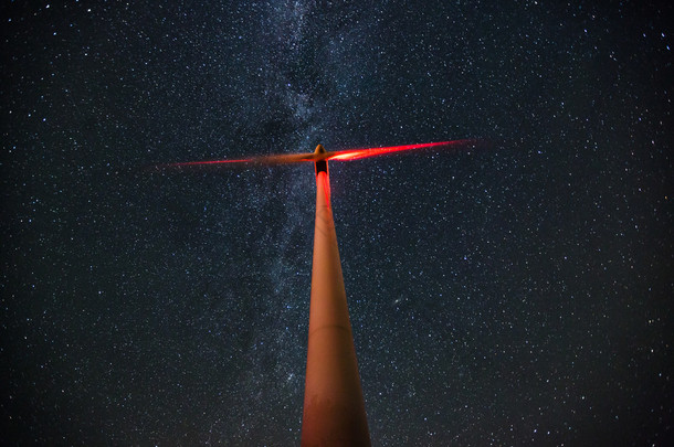 银河的繁星闪烁的夜晚天空的风力涡轮机