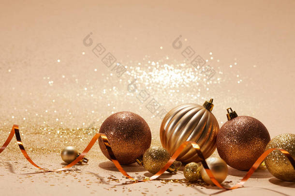 米色桌面上闪闪发亮的<strong>圣诞</strong>球和波浪丝带
