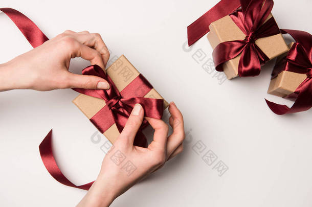 在白色的礼品盒上的妇女绑丝带的部分看法