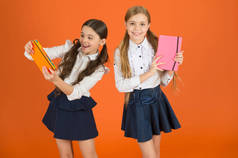 亲爱的日记学校文具。女孩可爱的孩子校服橙色背景。女学生展示书籍日记或记事本。学校用品概念。我们喜欢在学校学习。朋友记事本的个人资料