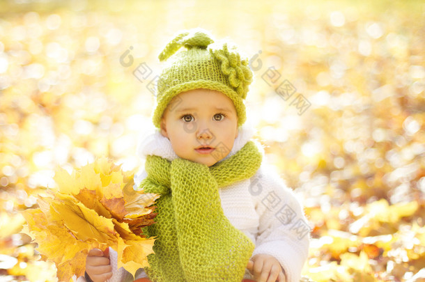 秋天黄叶中的秋天婴儿画像，毛帽中的小孩，公园户外的漂亮小孩，十<strong>月</strong>季节的针织服装