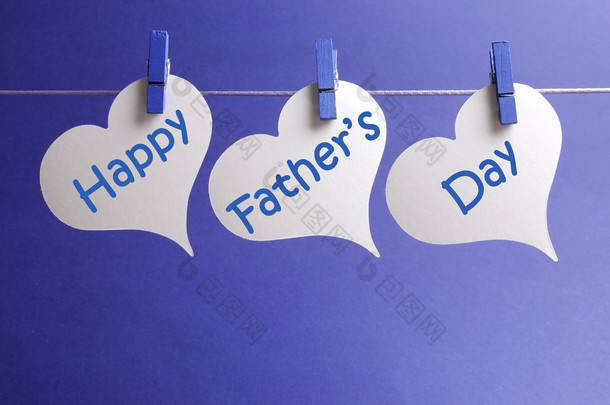 快乐的父亲一天消息写在白心形状标签挂在蓝钉上一线蓝色的<strong>背景</strong>上.
