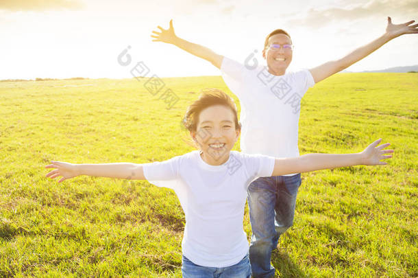 快乐的家庭父亲和孩子在草地上<strong>奔跑</strong>