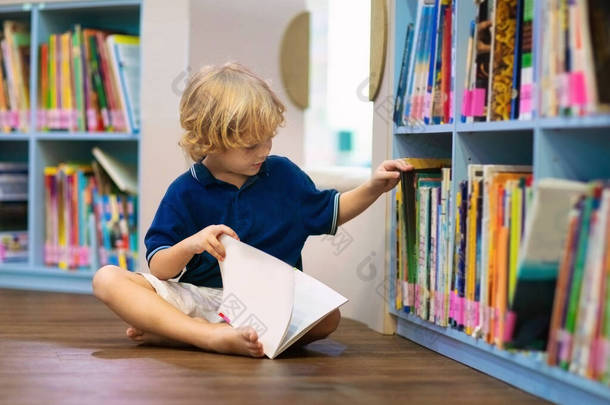 学校图书馆里的孩子孩子们看书。小男孩读书和学习。书店的孩子们聪明的学龄前儿童选择借书.