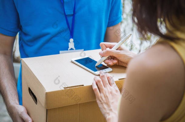 女人附加标志签名后接受从送货员，接收盒交货接收和交付概念 
