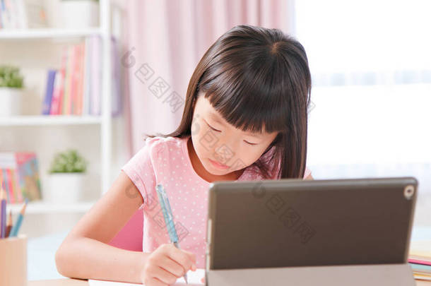亚洲女<strong>学生</strong>在家里用平板<strong>电脑</strong>愉快地上网上课