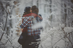 爱的情侣漫步在白雪皑皑的冬日森林