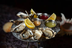 有柠檬的牡蛎盘子, 上面有牡蛎和柠檬。新鲜牡蛎特写顶部视图。健康的海洋食品。在餐厅吃牡蛎饭。美味佳肴。海洋食品.