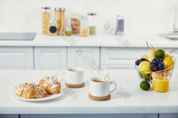 厨房白色桌面上的<strong>早餐</strong>杯<strong>咖啡</strong>和牛角面包的特写视图
