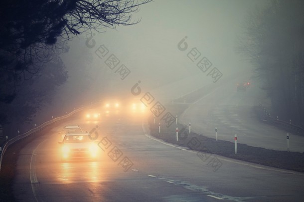 汽车在雾中。恶劣的冬季天气和<strong>路上</strong>危险的汽车交通。雾中的轻型车辆.
