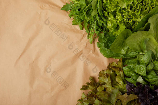 新鲜各种叶菜在皱巴巴的纸上的顶部视图