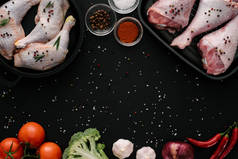 平躺与鸡肉和火鸡腿在平底锅与蔬菜和香料在黑暗的桌面上