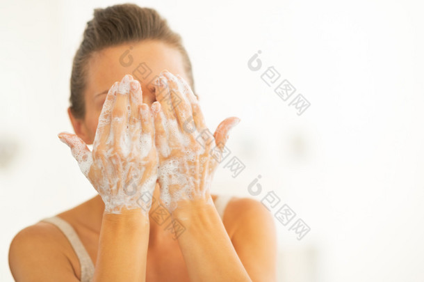 洗脸在浴室中的年轻女子