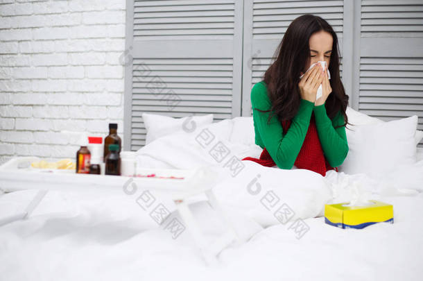 关闭<strong>一个</strong>年轻的生病的女人的肖像, 流鼻涕的红围巾躺在<strong>家</strong>里的床上和治疗。健康与疾病的概念.