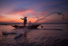 木船投掷自然河在早期期间日出时间淡水捕鱼网亚洲渔民的剪影