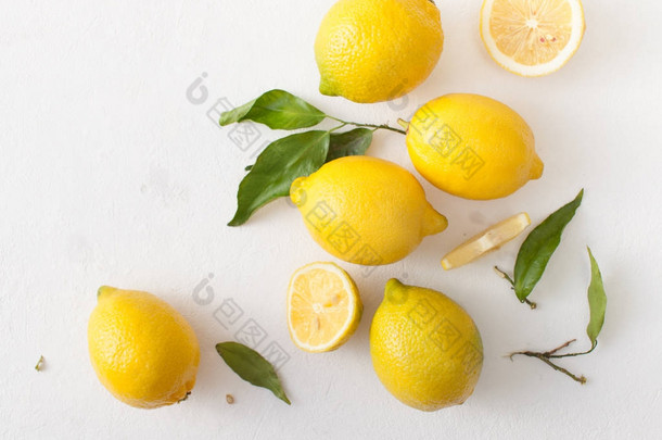 一束柠檬, 叶子和柠檬片在白色的水泥<strong>背景</strong>下.