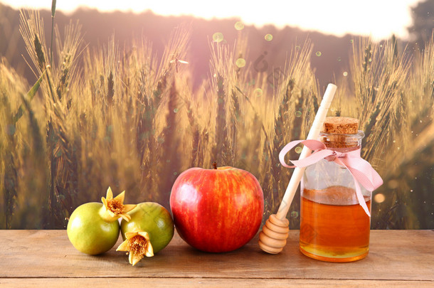 犹太新年 (jewesh 假日) 概念-蜂蜜、 苹果、 石榴在木桌。传统节日符号.