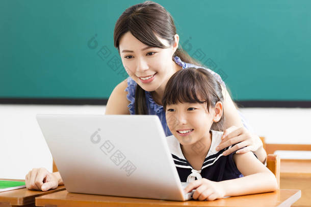 年轻的老师帮助孩子与<strong>计算机</strong>课