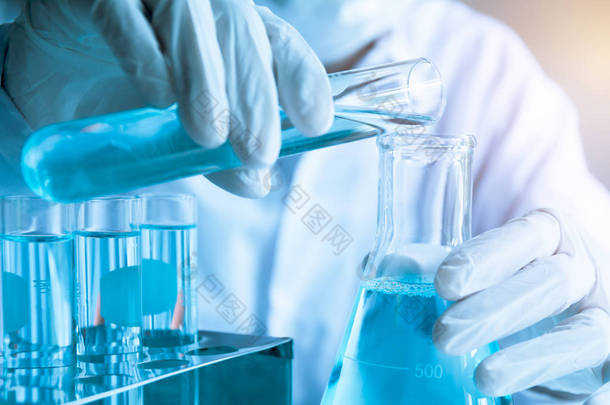 具有用于分析、医疗、制药和科学研究概念的液体玻璃实验室化学试管的研究人员.