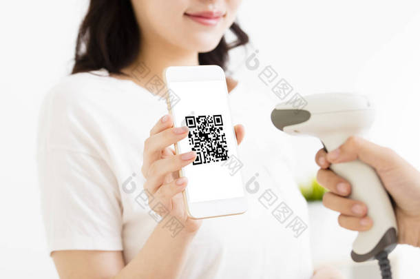 年轻女子用 qr 代码智能手机支付