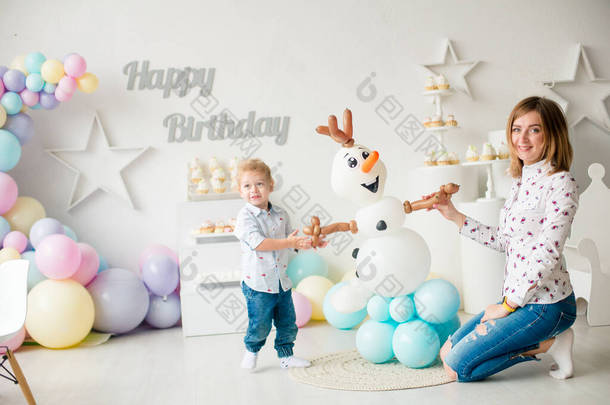 在孩子们的聚会上，一个带着气球和<strong>蛋糕</strong>的金发碧眼的小男孩在生日那天很可爱。孩子们的派对气球；气球
