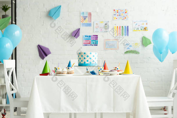 节日蛋糕和党帽在房间里装饰与气球生日派对
