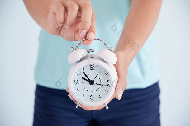 关闭一个生病的年轻妇女与时钟在她的手中。月经周期调节的概念。是时候照顾健康了