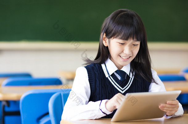 快乐漂亮的学生女孩在教室里的平板电脑