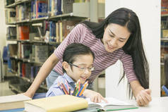 女教师和儿童学生在书架背景下学习书籍