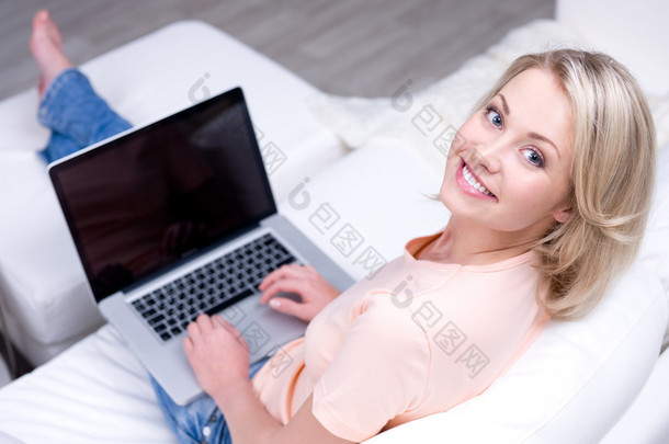 漂亮微笑妇女使用的便携式计算机