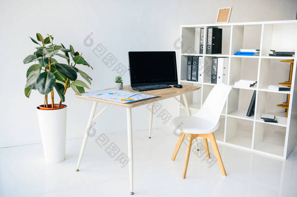 现代办公房内配有盆栽、椅、桌、图表、电脑及货架 
