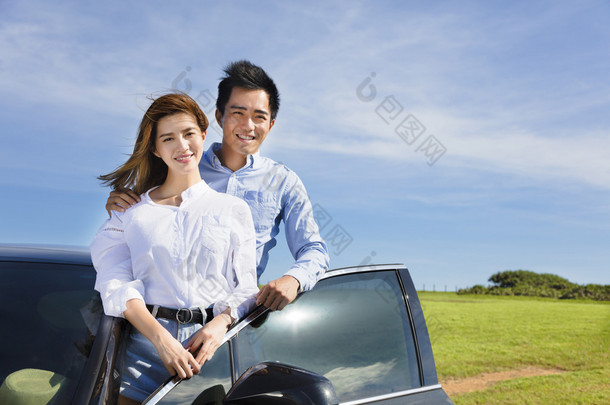 对年轻的夫妇<strong>站</strong>附近的汽车和享受暑假