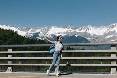 美丽的女孩与背包看着在雄伟的雪山, 勃朗峰, 阿尔卑斯山的全长视图