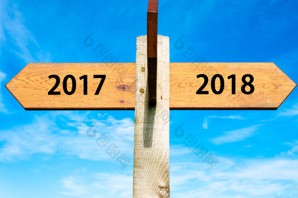 与两个相对的箭头，在湛蓝的天空、 <strong>2017年</strong>、 2018 <strong>年</strong>标志、 新<strong>年</strong>快乐概念形象的木制路标