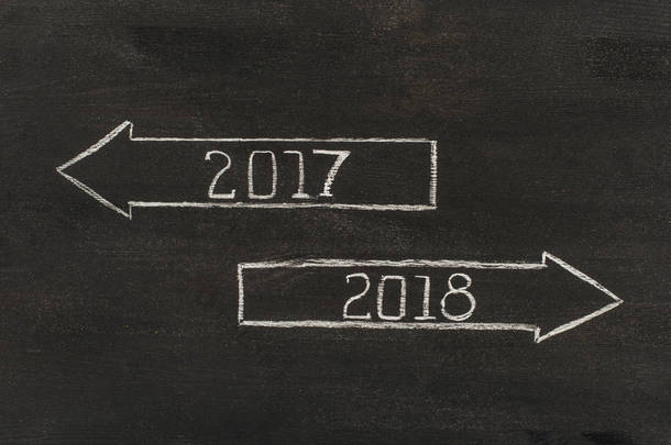 顶部视图箭头与 2017, 2018 年标志在黑暗的木桌面