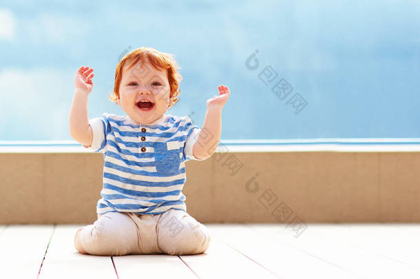 可爱的兴奋蹒跚学步婴儿在地板玩乐