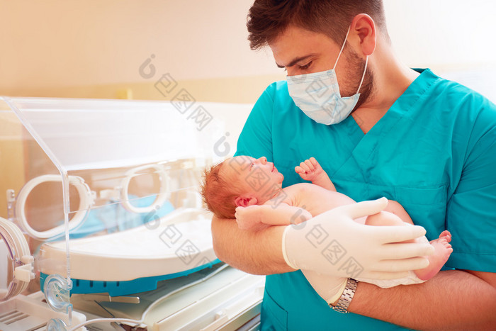 年轻的成年男子在医院抱着新生的婴儿