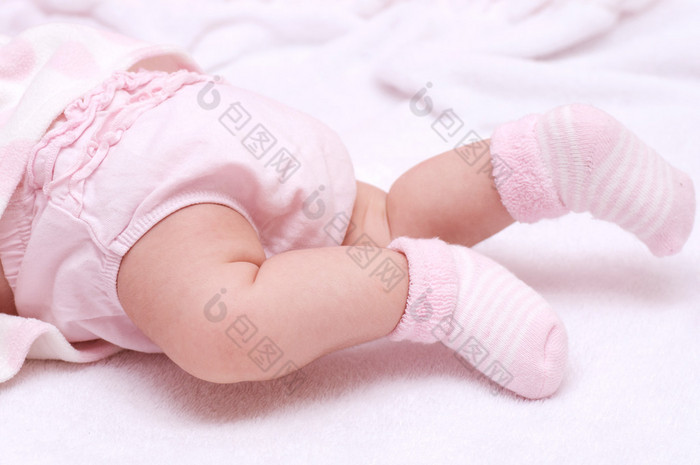 刚出生的婴儿的女孩脚穿着粉红色的袜子