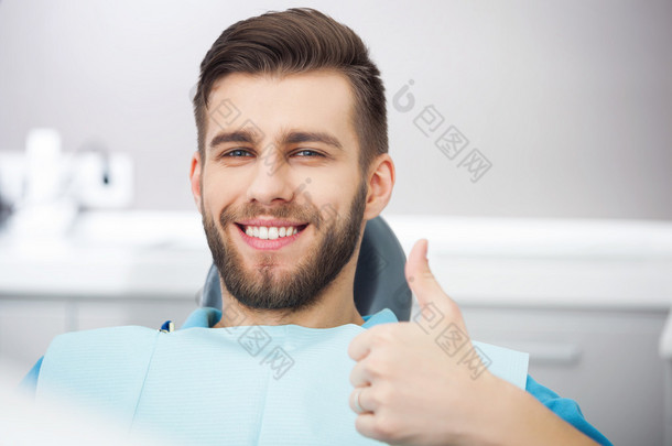 快乐患者坐在牙医的椅子上