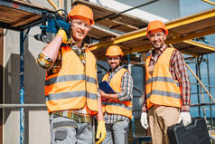 微笑建设者与建筑设备站在建筑工地