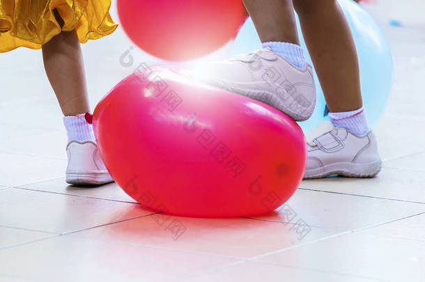 对小学生进行色彩体育竞赛, 实行伦理、纪律、<strong>和谐</strong>, 另一款气球踏板打破的游戏, 是一种关系, 男孩踩红气球.