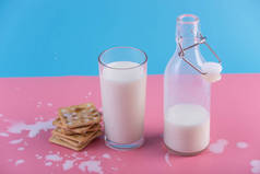用玻璃瓶装鲜奶和饼干，背景为彩色。多彩的极简主义。hea的概念