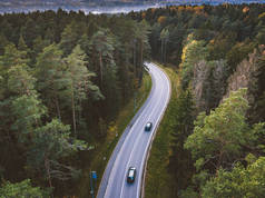 在乡间小路上驾车穿过森林的汽车鸟瞰图。立陶宛考纳斯