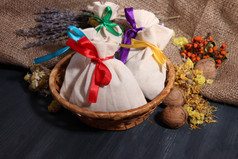 纺织干花、 草药和木制的桌子，麻布背景上的浆果香囊袋