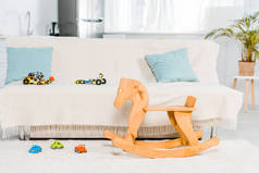 带沙发、汽车玩具和木制摇马的客厅的现代室内设计
