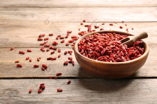 一碗干果子莓和勺子在木桌上，文本的空间。健康超级食品